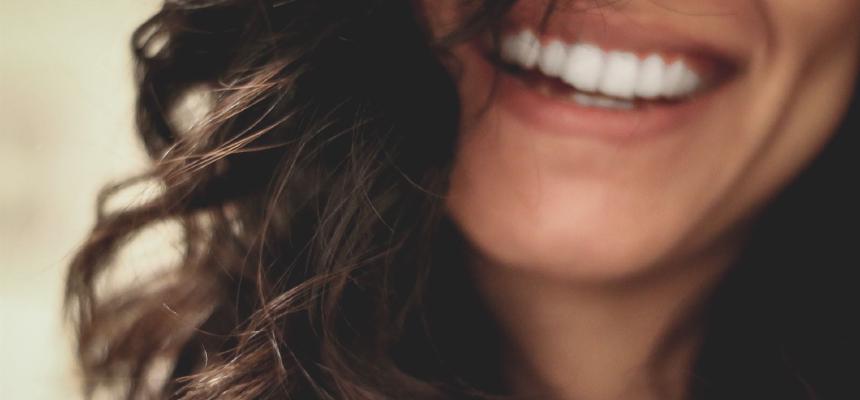 Vrouw die met haar blootgestelde tanden glimlacht