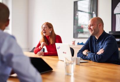 Foto de los empleados de Payt riéndose en una reunión en la sede