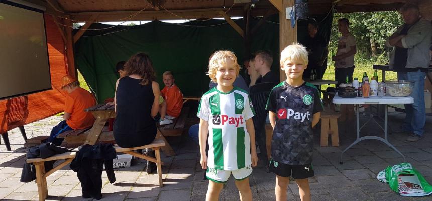 Foto van 2 kinderen met het FC Groningen tenue aan 