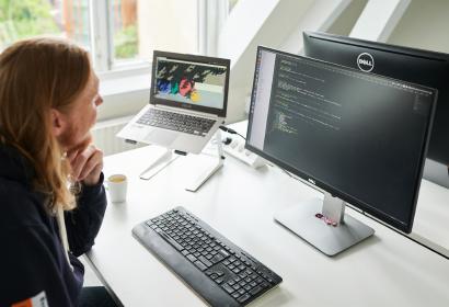 foto van een man die achter zijn computer aan het programmeren is